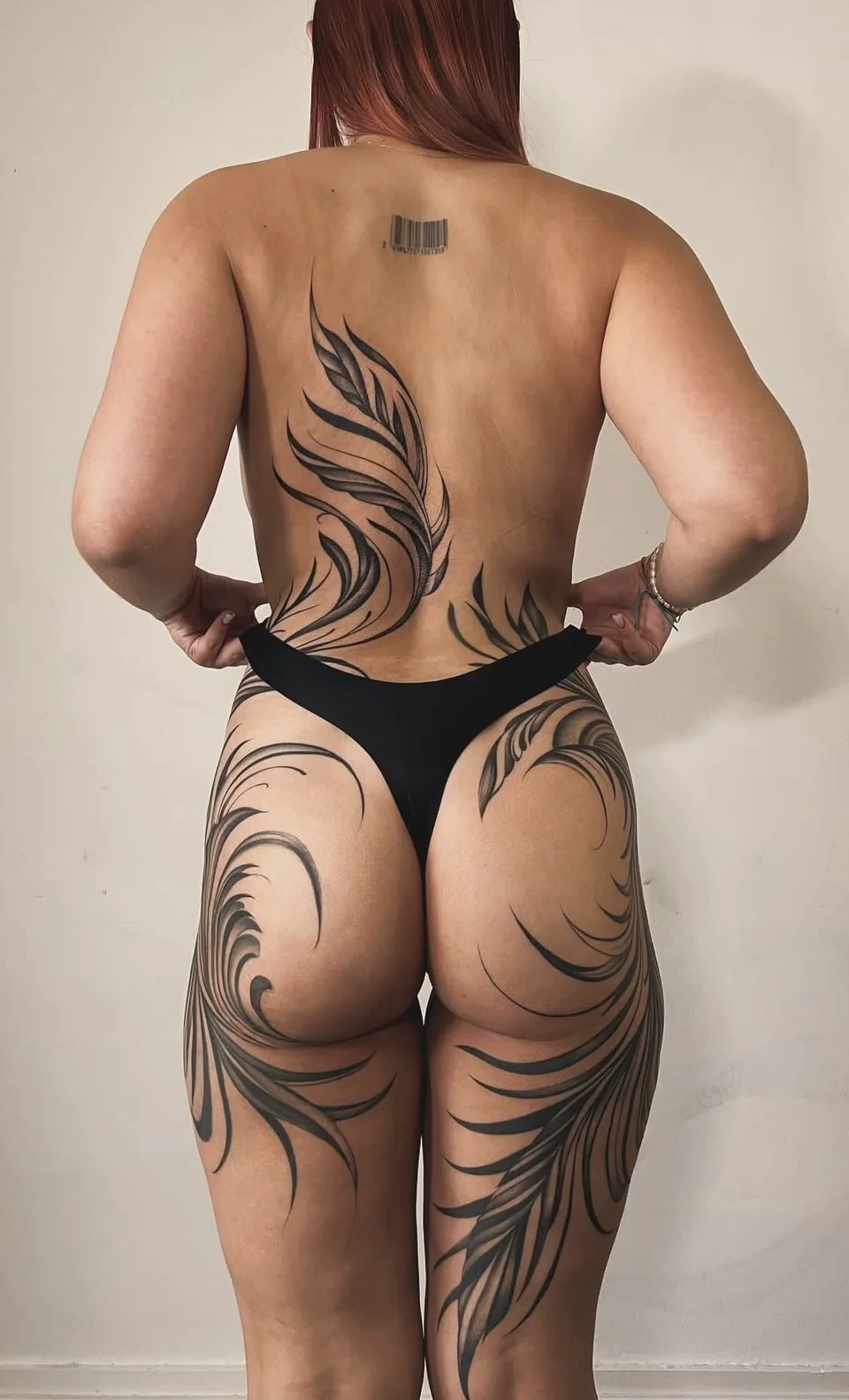 Tatouage ornemental accompagnant le dos, les hanches et les jambes, par Leali Tattoo