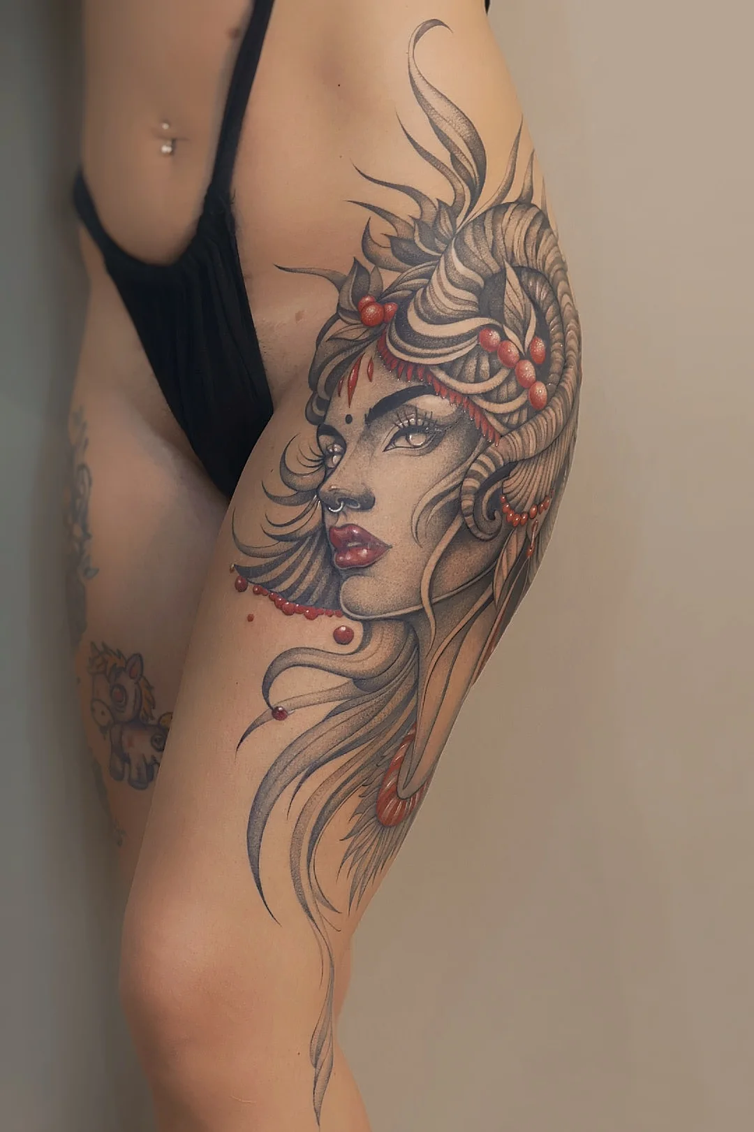 Portrait féminin ornemental tatoué sur le bras, avec des accents rouges, par Leali