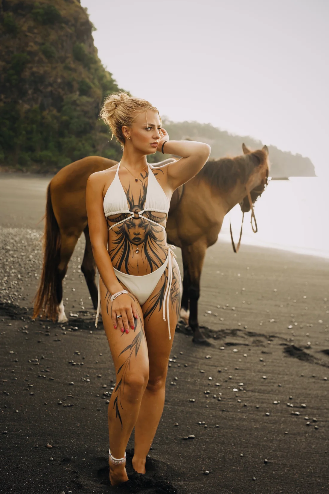 Femme tatouée accompagnée d’un cheval sur une plage, photographie éditoriale de Leali Tattoo